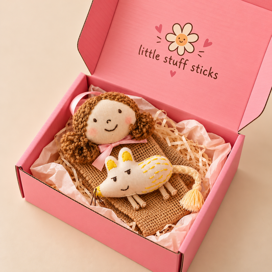 Hair clip organiser in an open pink gift box with the soft handmade doll head, fabric mouse and folded jute strip on tissue paper