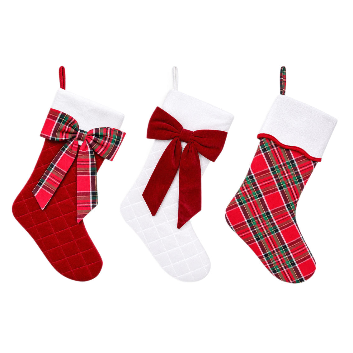 Three large Christmas stockings on a white background: red quilted velvet with a tartan bow, white quilted velvet with a red velvet bow, and classic red and green tartan with a white cuff